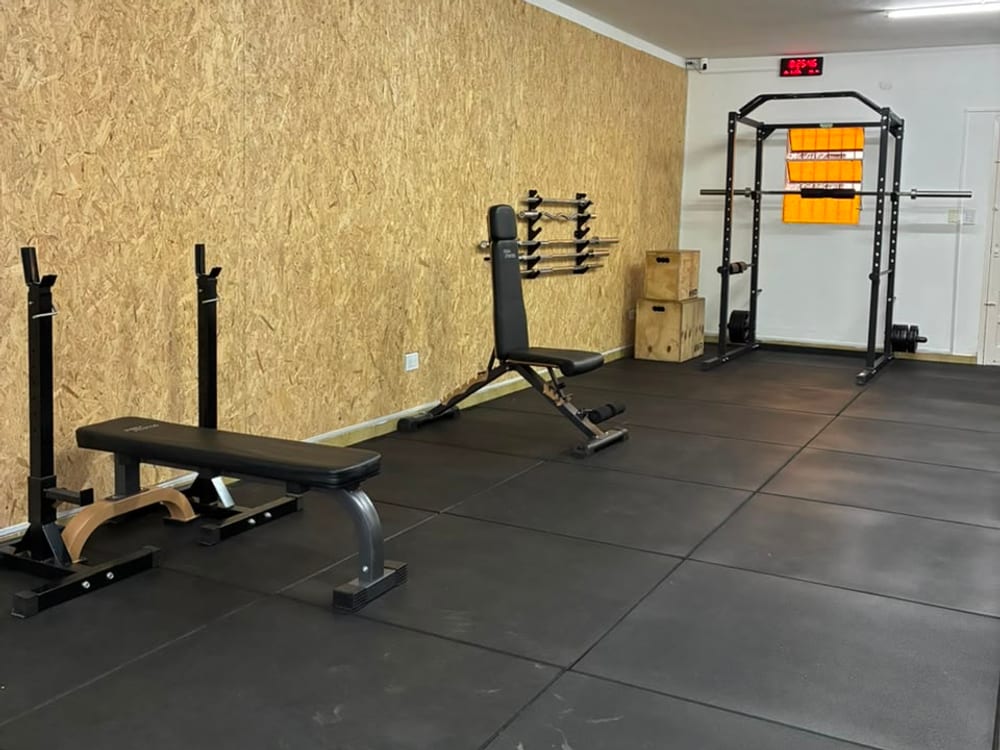 Sala de entrenamiento con bancos, sentadillera y cajones de salto
