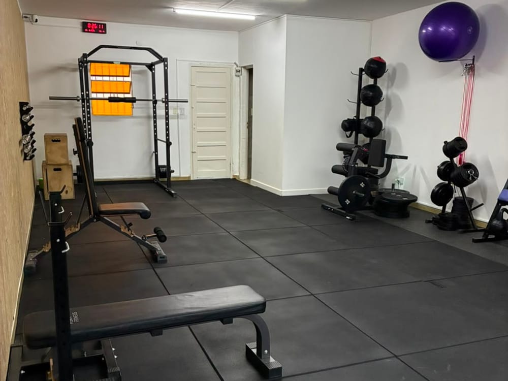 Rack de dominadas, banco y reloj de intervalos del salón principal